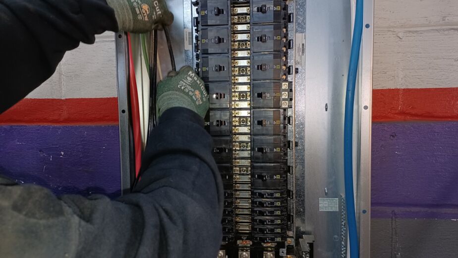 Closeup of someone working on wiring in a ul panel.