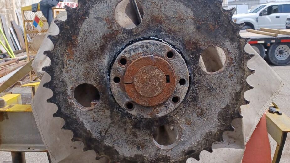 Reconditioning a large gear from a conveyor belt that is all rusted and grimy.